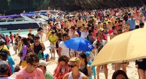 Overtourism Maya Bay Beach with crowds of people damaging ecosystem