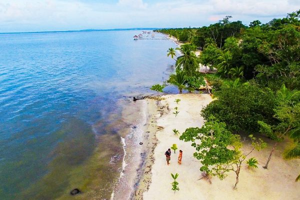 Blaues Wasser und Strandbesucher im Projekt Karibikküste Guatemala.