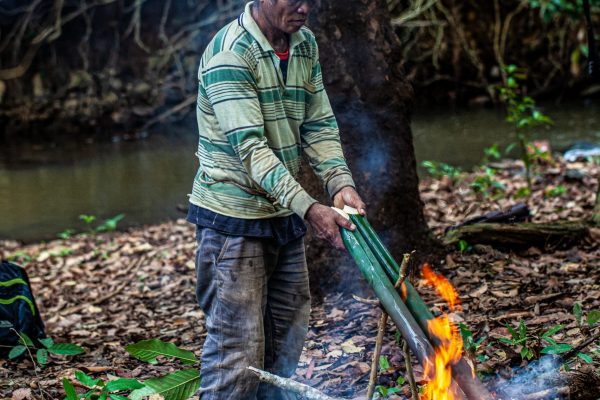 A member of the indigenous Bunung people cooking over an open fire in the Keo Seima project, Cambodia.
